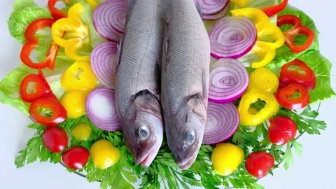 Chef's hand puts two slices of lemon between two fresh fish 库存影片 137264040