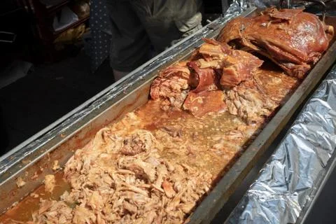 Chef's hand serving delicious pulled pork in a sandwich bun in a street marke Stock Photos