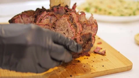 The chef's hand skillfully arranged the pieces of grilled meat, emphasizing its Stock Footage 273322906