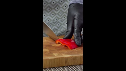 Chef's hand slicing red bell pepper on cutting board. Video stock 302638441
