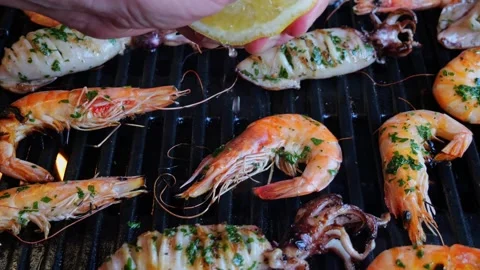 Chef's Hand Is Squeezing A Fresh Lemon Over Grill Shrimp. Slow Motion. Close up Stock Footage 252762601