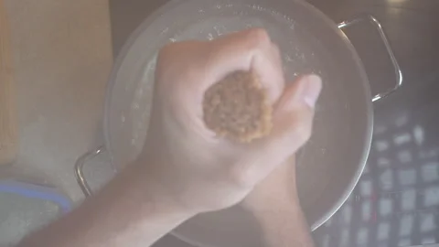 Chef's hands adding dried spaghetti pasta to boiling water. Stock Footage 302021394