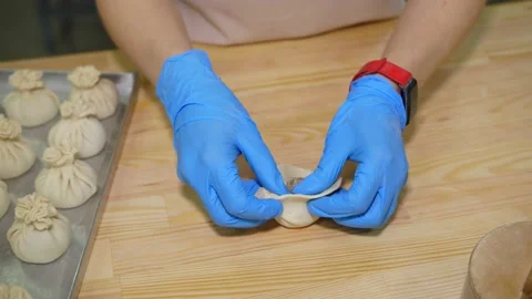 Chef's hands in blue gloves making Georgian food Khinkali. Video stock 238735539
