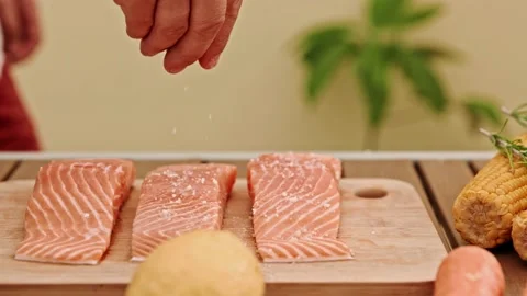 The chef's hands carefully sprinkle salt on the salmon fillets 스톡 동영상 232699304