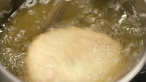 Chef's hands controlling the cooking of the cod patty into the pan with Stock Footage 130700772
