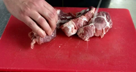 Chef's hands cut pork meat on a cutting board. Stock Footage 159161085