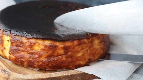 Chef's Hands cutting Basque Cheese Cake. 스톡 동영상 127881070