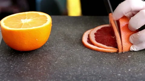 Chef's hands cutting fresh grapefruit on kitchen Stock Footage 98763814