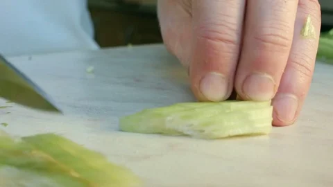Chefs hands cutting a fresh green celery leaf. Video stock 80115770
