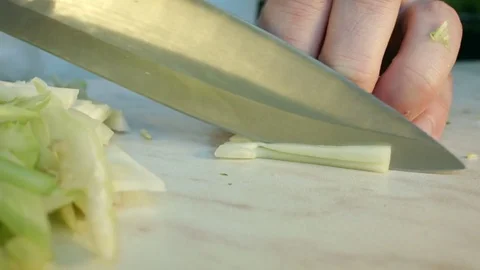 Chefs hands cutting a fresh green celery leaf. 動画素材 80115848