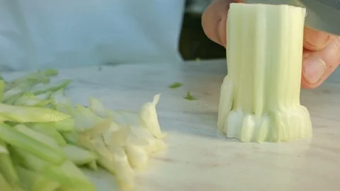 Chefs hands cutting a fresh green celery leaf. 動画素材 80180498
