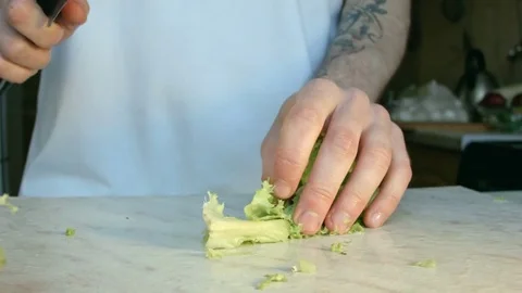 Chefs hands cutting a fresh green salad leaf. Stockbeeldmateriaal 80255264