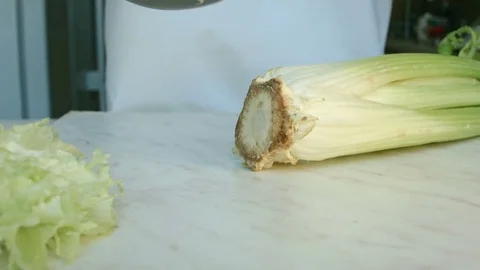 Chefs hands cutting a fresh green celery leaf. Vidéo 80255299