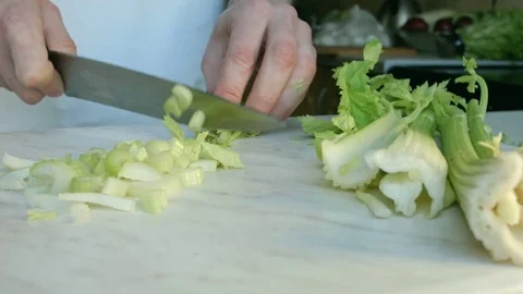 Chefs hands cutting a fresh green celery leaf. Stock Footage 80255373