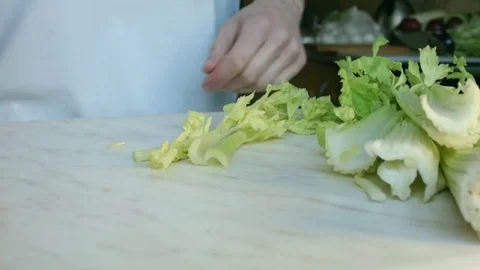 Chefs hands cutting a fresh green celery leaf. Video stock 80255379