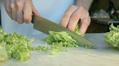 Chefs hands cutting a fresh green salad leaf. Vídeo Stock 80255485