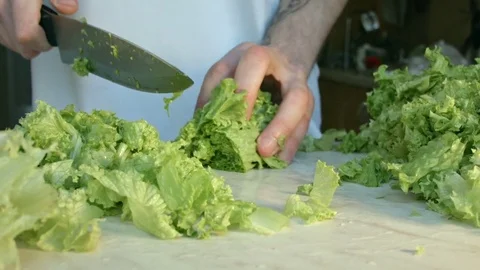 Chefs hands cutting a fresh green salad leaf. Stock Footage 80255541