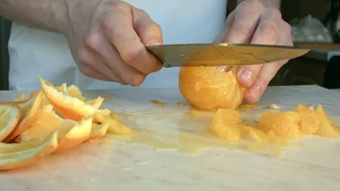 Chefs hands cutting a fresh orange. 스톡 동영상 80186885