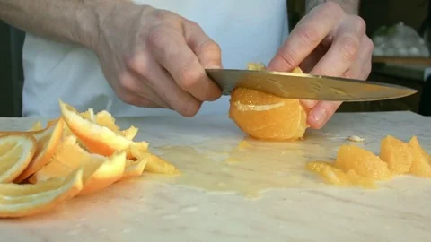 Chefs hands cutting a fresh orange. Video stock 80186899