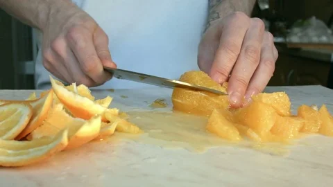 Chefs hands cutting a fresh orange. 스톡 동영상 80186901