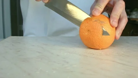 Chefs hands cutting a fresh orange. Stock Footage 80186904