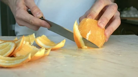 Chefs hands cutting a fresh orange. Video stock 80189384