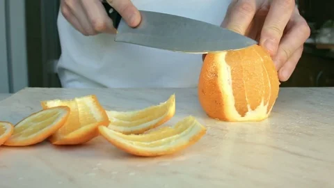 Chefs hands cutting a fresh orange. 動画素材 80189412