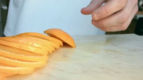 Chefs hands cutting a fresh orange. Video stock 80471499