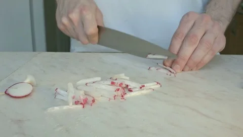 Chefs hands cutting a fresh radish. Vidéo 80074314