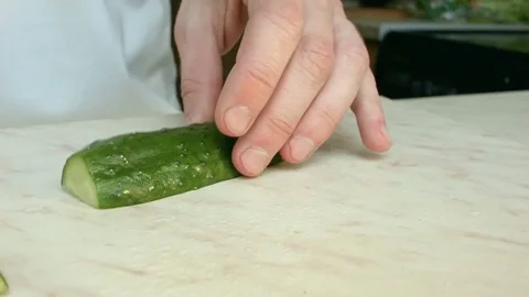 Chefs hands cutting a green fresh cucumber. Vídeo Stock 80238940