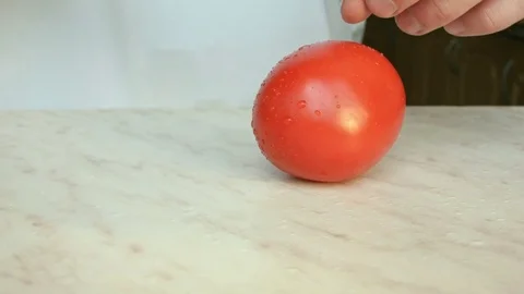 Chefs hands cutting a red fresh tomato Vídeo Stock 80238906