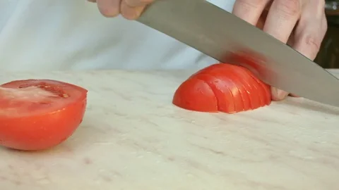 Chefs hands cutting a red fresh tomato. Video stock 80441304