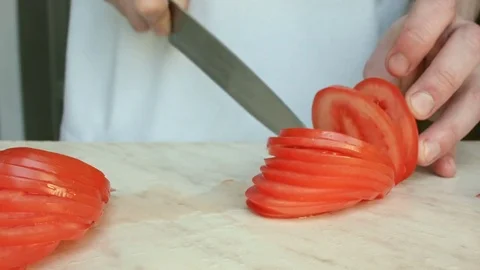 Chefs hands cutting a red fresh tomato. Vídeo Stock 80441685