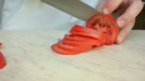 Chefs hands cutting a red fresh tomato. Video stock 80441699