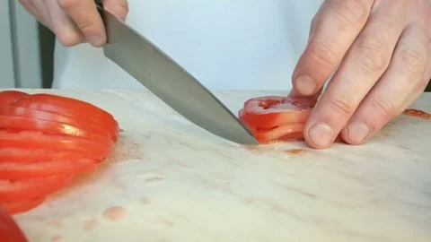 Chefs hands cutting a red fresh tomato. Vídeo Stock 80460082