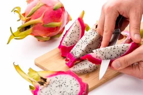 Chefs hands detaching pulp from a pitaya wedge Stock Photos