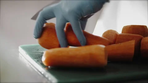 The chef's hands in gloves cut carrots in the kitchen. food concept Video stock 149147449