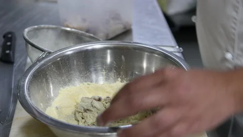 Chef's hands in the kitchen of a restaurant coating baby squids in flour Stock Footage 220947532