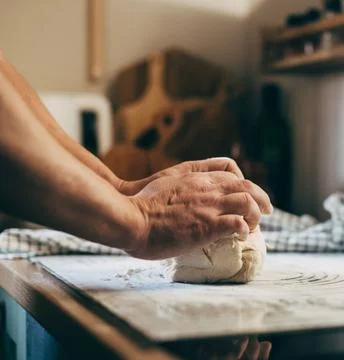 Chefs Hands Kneading Fresh Bread Dough on a Floured Worktop Stock Photos