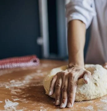 Chefs Hands Kneading Fresh Bread Dough on a Floured Worktop Stock Photos