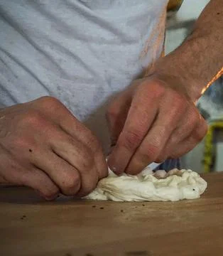 Chefs Hands Kneading Fresh Bread Dough on a Floured Worktop Stock Photos