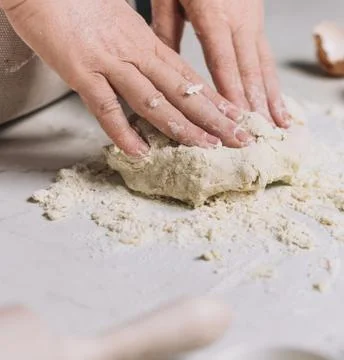 Chefs Hands Kneading Fresh Bread Dough on a Floured Worktop Stock Photos