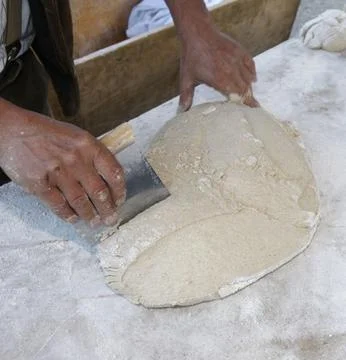 Chefs Hands Kneading Fresh Bread Dough on a Floured Worktop Stock Photos
