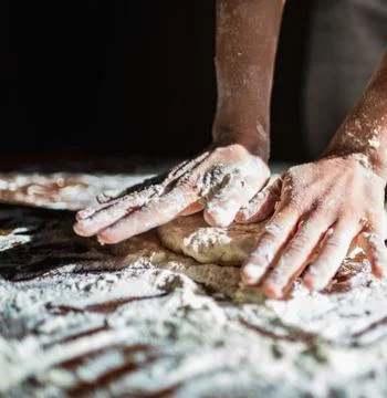 Chefs Hands Kneading Fresh Bread Dough on a Floured Worktop Stock Photos