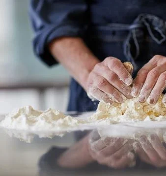 Chefs Hands Kneading Fresh Bread Dough on a Floured Worktop Stock Photos