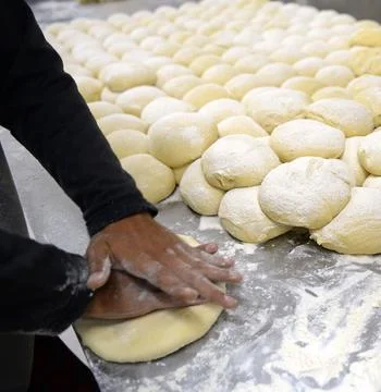 Chefs Hands Kneading Fresh Bread Dough on a Floured Worktop Stock Photos