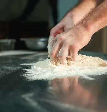 Chefs Hands Kneading Fresh Bread Dough on a Floured Worktop Stock Photos