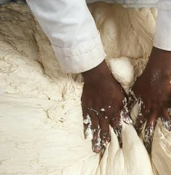 Chefs Hands Kneading Fresh Bread Dough on a Floured Worktop Stock Photos