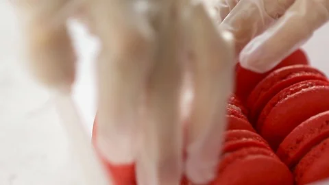 Chefs hands packaging fresh baked red strawberry macaroon into container Stock Footage 129784105