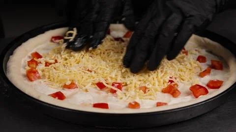 The chef's hands prepare the pizza and spread the cheese on the dough Stock Footage 261120130
